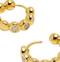 Gold hoop earrings with embedded gemstones on a white background
