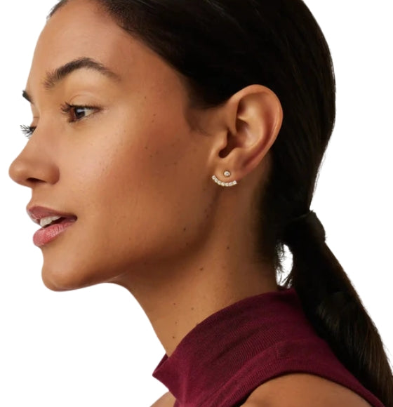 Close-up of a woman wearing a small hoop earring on a white background