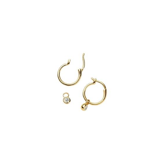 Gold hoop earrings with small round pendants on a white background
