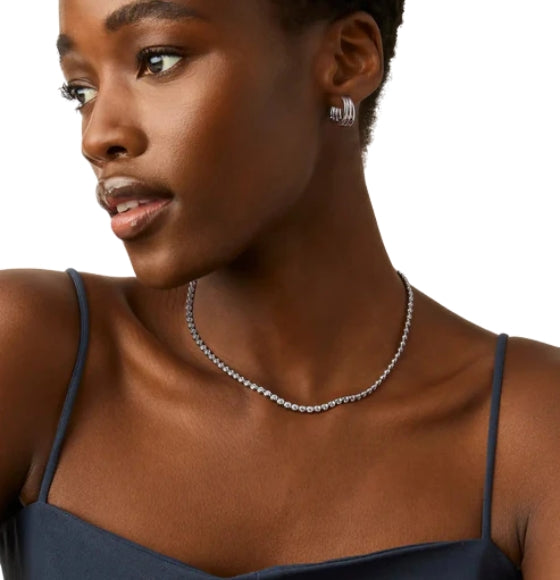 Woman wearing a necklace and earrings on a white background