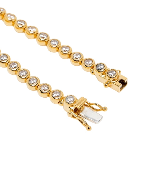 Gold bracelet with clear stones on a white background
